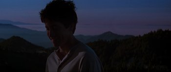 Movie still from “Donnie Darko” (2001), directed by Richard Kelly – A man standing on top of a hill at night; Close Up shot, Over the shoulder angle