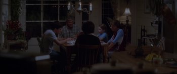 Movie still from “Donnie Darko” (2001), directed by Richard Kelly – A group of people sitting around a table at night; Wide shot, High angle