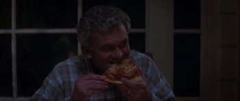 Movie still from “Donnie Darko” (2001), directed by Richard Kelly – An older man eating a piece of pizza; Close Up shot, High angle