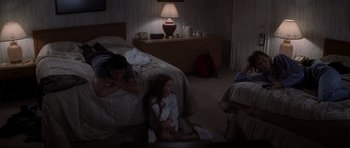 Movie still from “Donnie Darko” (2001), directed by Richard Kelly – A little girl sitting on the floor in front of a bed; Wide shot, High angle