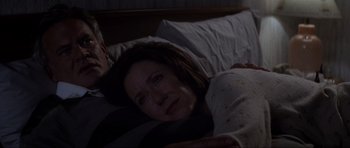 Movie still from “Donnie Darko” (2001), directed by Richard Kelly – A woman laying in a bed next to a man; Medium shot, Overhead angle