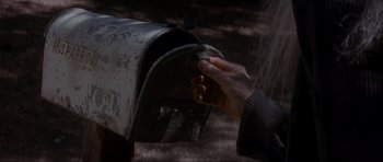 Movie still from “Donnie Darko” (2001), directed by Richard Kelly – A hand is reaching out of an open mailbox; Extreme Close Up shot, Low angle