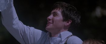 Movie still from “Donnie Darko” (2001), directed by Richard Kelly – A person wearing a white shirt and suspenders; Close Up shot, Low angle