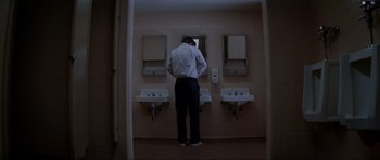 Movie still from “Donnie Darko” (2001), directed by Richard Kelly – A man standing in front of a bathroom mirror; Wide shot, Low angle