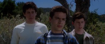 Movie still from “Donnie Darko” (2001), directed by Richard Kelly – A group of young men standing next to each other in a field; Close Up shot, Low angle