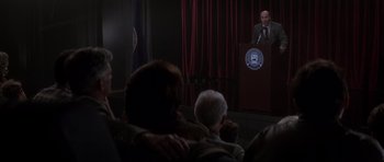 Movie still from “Donnie Darko” (2001), directed by Richard Kelly – A man giving a speech to a crowd of onlookers; Wide shot, Over the shoulder angle