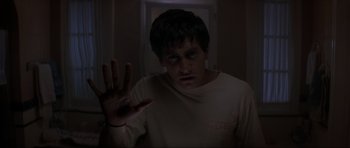 Movie still from “Donnie Darko” (2001), directed by Richard Kelly – A young man holding up his hand in a dark room; Close Up shot, Low angle