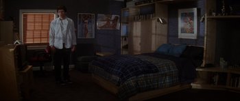 Movie still from “Donnie Darko” (2001), directed by Richard Kelly – A bedroom with a bed , a chair , and a painting; Wide shot, High angle
