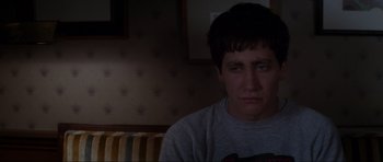 Movie still from “Donnie Darko” (2001), directed by Richard Kelly – A man sitting in front of a wall with his eyes wide open; Close Up shot, High angle