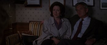 Movie still from “Donnie Darko” (2001), directed by Richard Kelly – A woman sitting on top of a couch in front of a man; Medium shot, High angle