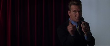 Movie still from “Donnie Darko” (2001), directed by Richard Kelly – A man wearing a suit and tie pointing at the camera; Medium shot, Low angle