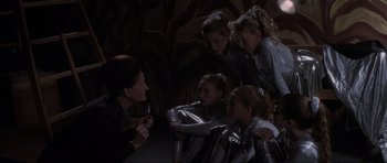 Movie still from “Donnie Darko” (2001), directed by Richard Kelly – A group of young girls are gathered around a woman; Medium shot, High angle