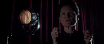 Movie still from “Donnie Darko” (2001), directed by Richard Kelly – A woman standing in front of a stage light; Close Up shot, Low angle