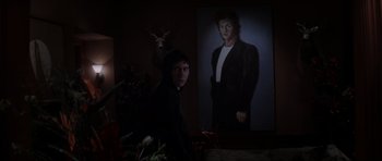 Movie still from “Donnie Darko” (2001), directed by Richard Kelly – A man standing in front of a picture of himself; Medium shot, Over the shoulder angle