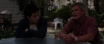 Movie still from “Donnie Darko” (2001), directed by Richard Kelly – Two men sitting at a table with a glass of whiskey; Medium shot, Over the shoulder angle