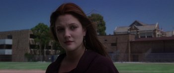 Movie still from “Donnie Darko” (2001), directed by Richard Kelly – A woman with long red hair standing in front of a brick building; Close Up shot, Low angle