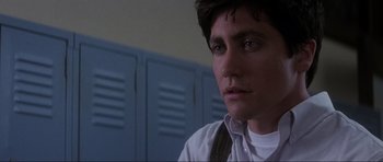 Movie still from “Donnie Darko” (2001), directed by Richard Kelly – A young man in a white shirt in front of blue lockers; Close Up shot, Low angle
