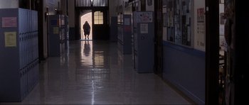Movie still from “Donnie Darko” (2001), directed by Richard Kelly – A person is walking down a hallway in a building; Extreme Wide shot, Low angle