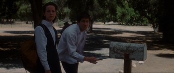 Movie still from “Donnie Darko” (2001), directed by Richard Kelly – A man and a woman are playing frisbee in a park; Medium shot, Low angle
