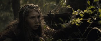 Movie still from “Don't Breathe 2” (2021), directed by Rodo Sayagues – A young girl in the woods looking at the camera; Close Up shot, Low angle