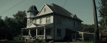 Movie still from “Don't Breathe 2” (2021), directed by Rodo Sayagues – An old house with a large porch and a large chimney; Extreme Wide shot, Low angle