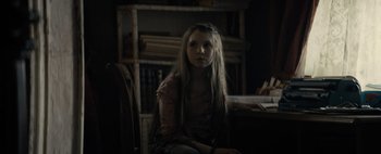 Movie still from “Don't Breathe 2” (2021), directed by Rodo Sayagues – A girl sitting in front of a book shelf; Close Up shot, High angle