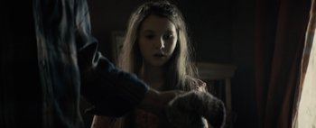 Movie still from “Don't Breathe 2” (2021), directed by Rodo Sayagues – A young girl holding a teddy bear in a dark room; Close Up shot, Over the shoulder angle