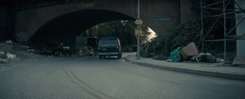 Movie still from “Don't Breathe 2” (2021), directed by Rodo Sayagues – A van driving down a street under a bridge; Wide shot, High angle