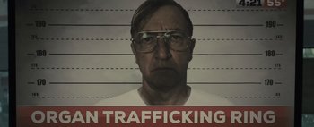 Movie still from “Don't Breathe 2” (2021), directed by Rodo Sayagues – A mugshot of a man with glasses and a white shirt on; Close Up shot, Low angle