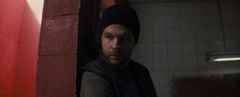 Movie still from “Don't Breathe 2” (2021), directed by Rodo Sayagues – A man wearing a black hat and a black jacket; Close Up shot, Over the shoulder angle