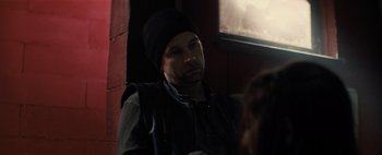 Movie still from “Don't Breathe 2” (2021), directed by Rodo Sayagues – A man wearing a black hat and a black jacket; Close Up shot, Over the shoulder angle