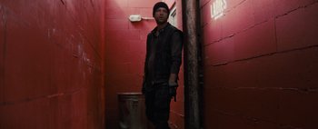 Movie still from “Don't Breathe 2” (2021), directed by Rodo Sayagues – A man standing in a hallway with a red brick wall behind him; Medium shot, Low angle