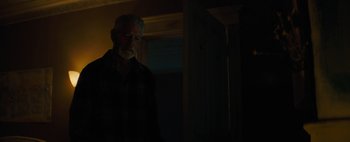 Movie still from “Don't Breathe 2” (2021), directed by Rodo Sayagues – An older man standing in a dark room; Medium shot, Low angle