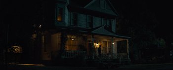 Movie still from “Don't Breathe 2” (2021), directed by Rodo Sayagues – A person standing outside of a house at night; Extreme Wide shot, Low angle