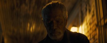 Movie still from “Don't Breathe 2” (2021), directed by Rodo Sayagues – An old man with a gray beard is looking at the camera; Close Up shot, Low angle