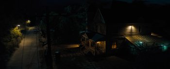 Movie still from “Don't Breathe 2” (2021), directed by Rodo Sayagues – A house that is lit up at night time; Extreme Wide shot, High angle