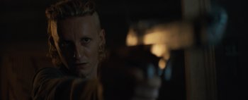 Movie still from “Don't Breathe 2” (2021), directed by Rodo Sayagues – A man with a shaved head is looking at the camera; Close Up shot, Low angle