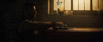 Movie still from “Don't Breathe 2” (2021), directed by Rodo Sayagues – A man sitting at a table in front of a window; Medium shot, Over the shoulder angle