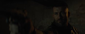 Movie still from “Don't Breathe 2” (2021), directed by Rodo Sayagues – A person with a gun in a dark room; Close Up shot, Over the shoulder angle