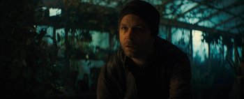 Movie still from “Don't Breathe 2” (2021), directed by Rodo Sayagues – A man in a black jacket and a black hat; Close Up shot, Over the shoulder angle