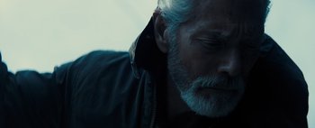 Movie still from “Don't Breathe 2” (2021), directed by Rodo Sayagues – An older man with a beard and a jacket on; Close Up shot, Over the shoulder angle