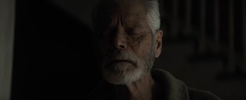 Movie still from “Don't Breathe 2” (2021), directed by Rodo Sayagues – An old man with a gray beard is looking sad; Close Up shot, Low angle