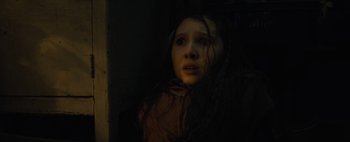 Movie still from “Don't Breathe 2” (2021), directed by Rodo Sayagues – A woman with long dark hair is looking out of a window; Close Up shot, Low angle