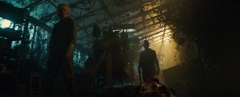 Movie still from “Don't Breathe 2” (2021), directed by Rodo Sayagues – A man standing in a room with a bunch of plants; Wide shot, Low angle