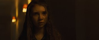 Movie still from “Don't Breathe 2” (2021), directed by Rodo Sayagues – A young woman with long hair stares into the camera; Close Up shot, Over the shoulder angle