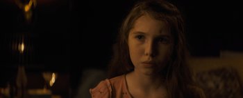 Movie still from “Don't Breathe 2” (2021), directed by Rodo Sayagues – A young girl with long red hair is looking at the camera; Close Up shot, High angle