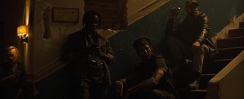 Movie still from “Don't Breathe 2” (2021), directed by Rodo Sayagues – Two men sitting on the ground in a dark room; Medium shot, Low angle