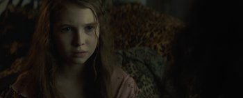 Movie still from “Don't Breathe 2” (2021), directed by Rodo Sayagues – A young girl with long brown hair is looking at the camera; Close Up shot, Over the shoulder angle