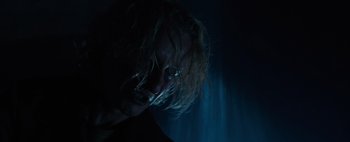Movie still from “Don't Breathe 2” (2021), directed by Rodo Sayagues – A man with long hair and glasses in the dark; Close Up shot, Low angle