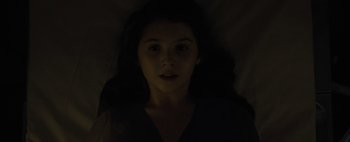 Movie still from “Don't Breathe 2” (2021), directed by Rodo Sayagues – A woman with long dark hair is in the dark; Close Up shot, Overhead angle